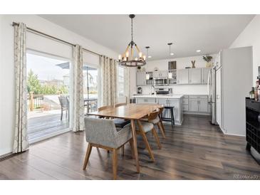 Modern kitchen and dining area with stainless steel appliances and natural light at 11048 Rifle Ct, Commerce City, CO 80022