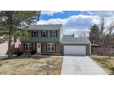 Charming two-story home with a well-manicured lawn, attached garage, and a welcoming exterior at 12426 W Temple Dr, Morrison, CO 80465