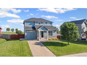 Charming two-story home with blue siding, a well-maintained lawn, and an attached one car garage at 7977 Emerson Ave, Frederick, CO 80530