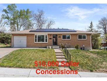 Charming brick home with a well-manicured lawn and solar panels installed on the roof at 4102 W Eastman Ave, Denver, CO 80236