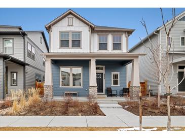 Charming two-story home with a welcoming front porch, stone accents, and manicured landscaping at 6334 N Dayton Way, Denver, CO 80238