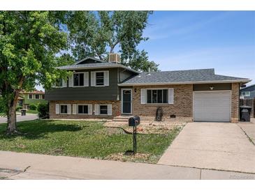 Charming home featuring a well-kept lawn, brick accents, attached garage, and inviting curb appeal at 4502 S Gar Way, Littleton, CO 80123