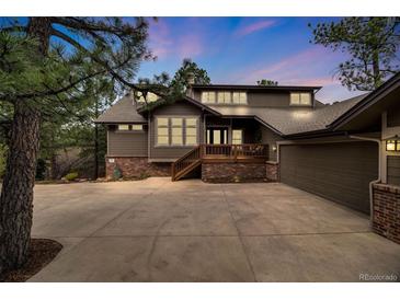 Charming two-story home with a well-manicured lawn and mature trees creating curb appeal at 1221 Havenwood Way, Castle Pines, CO 80108