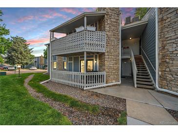Two-story condo featuring stone accents, a private balcony, and well-maintained landscaping at 8335 Fairmount Dr # 2-105, Denver, CO 80247