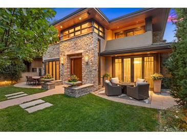 Beautiful stone home featuring an outdoor seating area and manicured lawn at 467 Saint Paul St, Denver, CO 80206