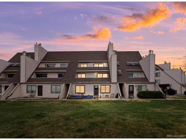A charming townhome featuring a well-maintained lawn and serene outdoor living space with a beautiful sunset at 4226 S Eldridge St # 207, Morrison, CO 80465