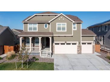 Charming two-story home showcasing a well-manicured lawn, attached three car garage, and inviting front porch at 16345 Milwaukee St, Thornton, CO 80602