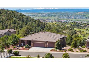Beautiful home with a three-car garage, lush landscaping, and mountain views at 438 Galaxy Dr, Castle Rock, CO 80108