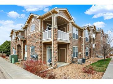 Inviting condo with stone accents, private balcony, and well-maintained landscaping at 7440 S Blackhawk St # 16-208, Englewood, CO 80112