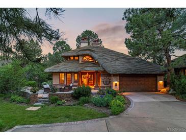Stunning home featuring a unique roof design, lush landscaping, and a welcoming entrance with a cozy seating area at 4406 Orofino Pl, Castle Rock, CO 80108
