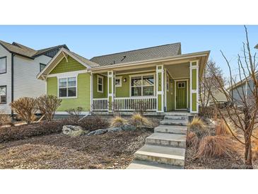 Charming single-Gathering home featuring a welcoming front porch, green siding and landscaped front yard at 2838 Cascade Creek Dr, Lafayette, CO 80026