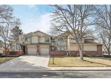 Inviting townhome with a well-maintained lawn, attached garage, and brick accents at 5243 Union Ct # 4, Arvada, CO 80002