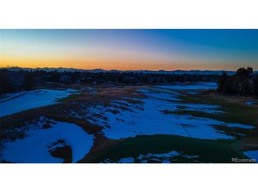 An aerial view of the golf course at dusk showing snow covering the green at 93 Glenmoor Dr, Englewood, CO 80113