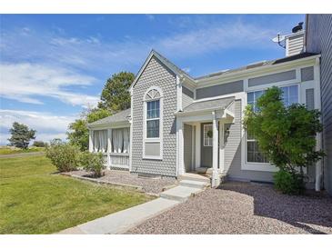 Charming home featuring unique shingle siding, a covered porch, and a well-maintained front yard at 10711 Longs Way, Parker, CO 80138