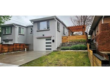 Charming home with modern garage door, landscaped yard and a covered patio at 20 S Harrison St, Denver, CO 80209