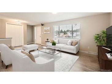Bright living room features a large window, plush seating, and modern decor at 9014 W Harvard Dr, Lakewood, CO 80227