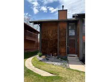 Charming two-story home featuring unique cedar shake siding and a well-manicured front yard with rock landscaping at 1273 S Crystal Way, Aurora, CO 80012