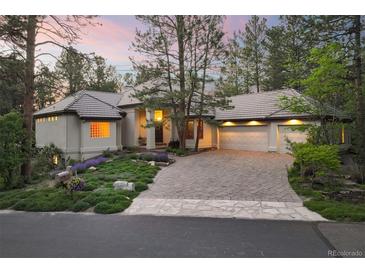Stunning exterior elevation features lush landscaping, stone driveway, and attached three-car garage at 474 Silbrico Way, Castle Rock, CO 80108
