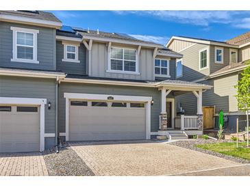 Charming two-story home with a brick driveway, garage, and covered porch, perfect for enjoying the outdoors at 645 Flintwood Pl, Lafayette, CO 80026
