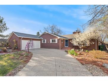 Charming brick home featuring a spacious driveway, attached garage, and beautifully landscaped front yard at 5285 E Iliff Ave, Denver, CO 80222
