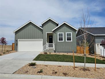 Charming single-Gathering home featuring a two-car garage, lovely front yard, and modern architectural details at 17125 W 92Nd Loop, Arvada, CO 80007