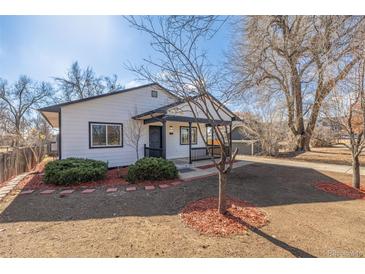 Charming single-story home featuring a covered porch and well-maintained front yard at 7008 Ralston Rd, Arvada, CO 80002