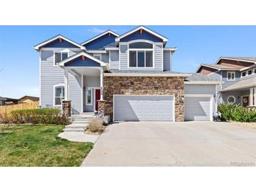 Charming two-story home with blue siding, stone accents, and a well-manicured front yard at 6739 Blue Spruce St, Frederick, CO 80530