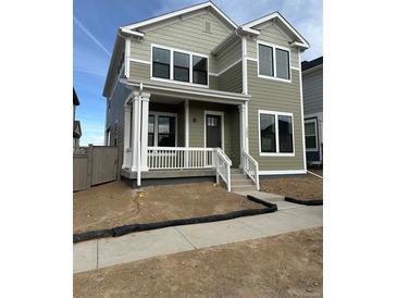 Charming two-story home with a welcoming front porch and well-lit windows at 203 Washington St, Erie, CO 80516