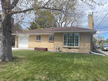 Charming brick home featuring a well-manicured lawn and attached garage, perfect for suburban living at 799 N Holly St, Denver, CO 80220