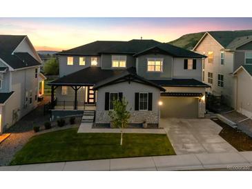 Beautiful two-story home featuring a well-maintained lawn, gray siding, and a two car garage at 359 Rogers Way, Castle Rock, CO 80104