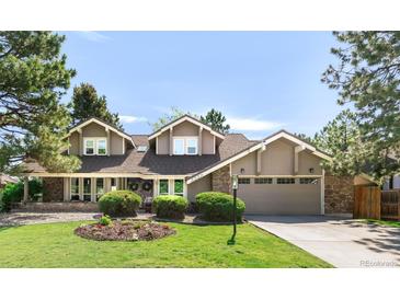 Charming two-story home featuring a well-manicured lawn, stone accents, and an attached two-car garage at 5557 E Links Cir, Centennial, CO 80122
