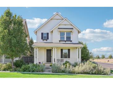 Charming two-story house with white siding, landscaping, and a front porch at 7902 E 49Th Pl, Denver, CO 80238