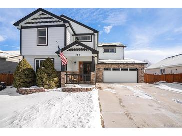 Two-story home with white siding, black accents, and a snow-covered front yard at 580 Mount Massive St, Berthoud, CO 80513