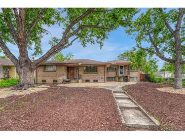 Charming brick duplex with mature trees, rock landscaping, and a walkway leading to the front entrance at 3854 Perry St, Denver, CO 80212
