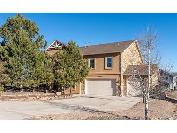 Two story home featuring attached two car garage, a landscaped front yard, and a large driveway at 1822 Painter Dr, Monument, CO 80132