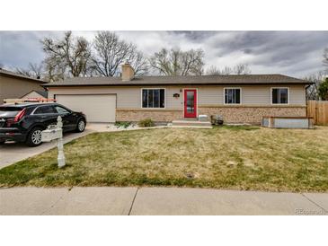 Charming single-story home featuring a red front door, attached garage, and well-maintained front yard at 11964 W 71St Pl, Arvada, CO 80004