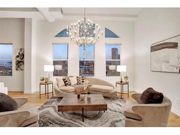 Bright living room featuring a modern chandelier, city views, and stylish furniture at 1521 Central St # 3C, Denver, CO 80211