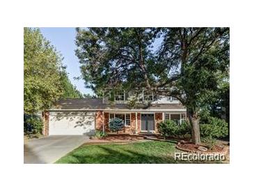 Charming two-story home with well-maintained landscaping, mature trees, and a welcoming front entrance at 7154 S Hudson Cir, Centennial, CO 80122