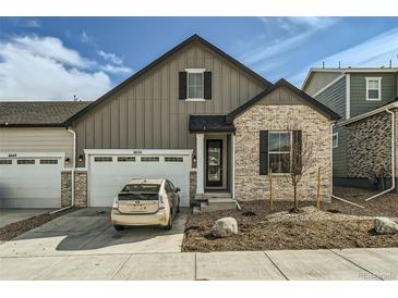 Charming two-story home featuring a front-facing garage and a blend of siding and brick accents at 6634 N Malta St, Aurora, CO 80019