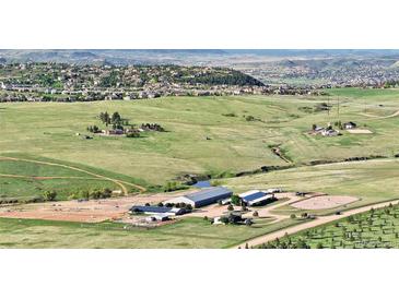 Expansive aerial view of equestrian estate with barns, pastures, and stunning mountain views at 1705 Outter Marker Rd, Castle Rock, CO 80108