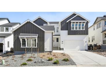 Two-story home featuring gray and white color scheme, landscaped front yard, and attached two-car garage at 3378 Backdrop Ct, Castle Rock, CO 80108