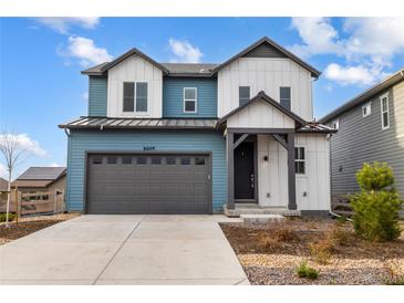 Modern two-story home with blue and white siding, a gray garage door, and a well-manicured lawn at 8609 Cheraw St, Littleton, CO 80125