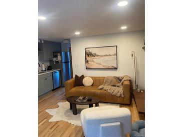 Inviting living room featuring a leather sofa, stylish decor, and an open layout connecting to the kitchen at 155 S Pennsylvania St # 209, Denver, CO 80209