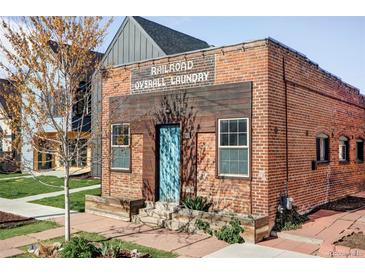 Charming brick building featuring 'Railroad Overall Laundry' signage, modern wood accents, and a vibrant blue door at 3733 N Franklin St, Denver, CO 80205