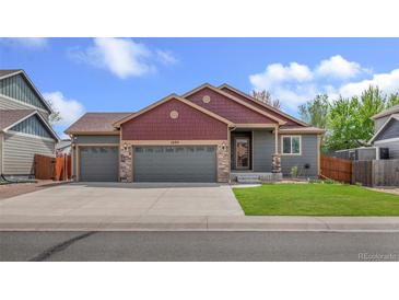 Charming two-story home featuring a three-car garage and well-maintained front yard at 1694 Jennifer St, Brighton, CO 80601