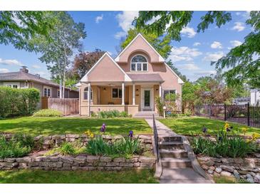 Charming two-story home with a landscaped yard, stone garden bed, and a welcoming front porch at 1459 S Elizabeth St, Denver, CO 80210