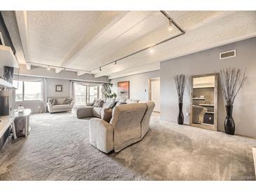 Spacious living room featuring recessed lighting, neutral tones, and balcony access at 7865 E Mississippi Ave # 602, Denver, CO 80247