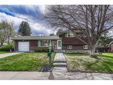 Charming two-story home with a well-maintained front yard, walkway, and wood facade under a partly cloudy sky at 7425 S Dexter St, Centennial, CO 80122