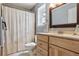 Well-lit bathroom with wood vanity, framed mirror, and shower with patterned shower curtain at 693 Delwood Ct, Highlands Ranch, CO 80126