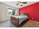 Comfortable bedroom featuring a large window seat, red accent wall, neutral tones, and plush carpeting at 693 Delwood Ct, Highlands Ranch, CO 80126